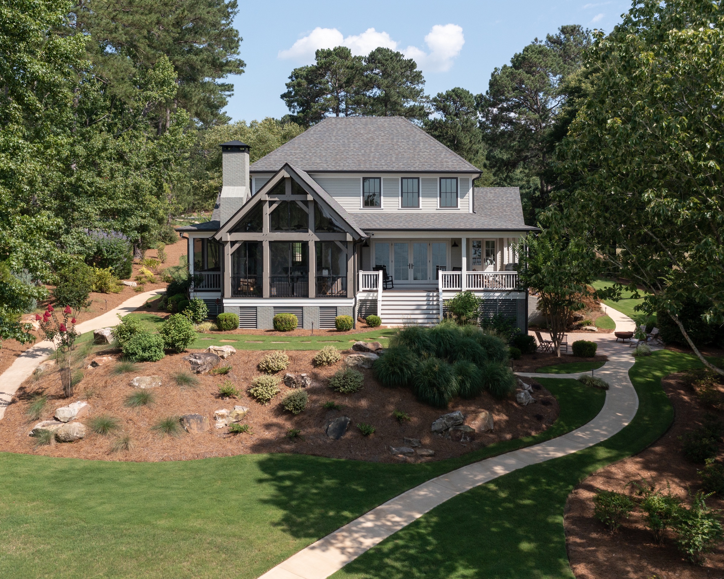 Lake Oconee custom home with timber-framed entry porch and stone hardscape, drone view